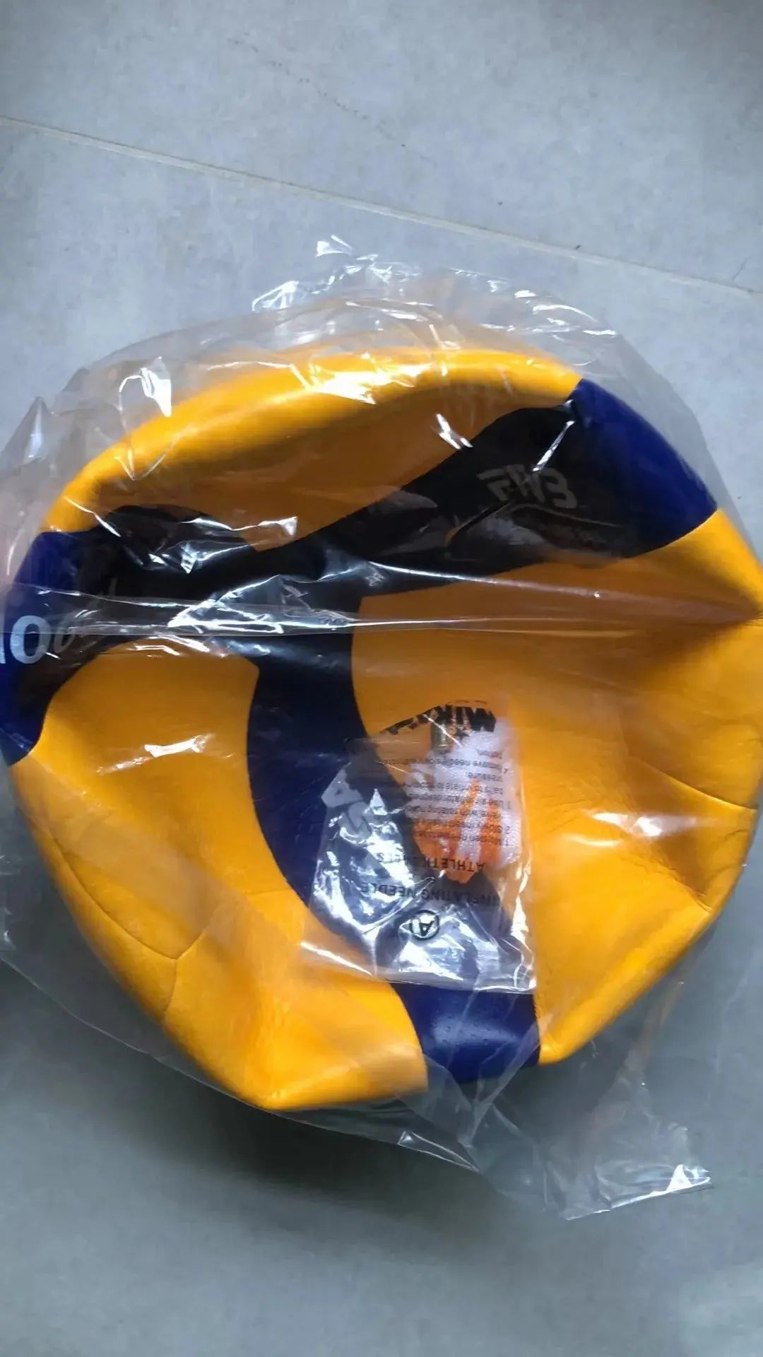 Original Zenn Organics Inc V200W V300W size 5 competition volleyball resting on a court with a textured surface